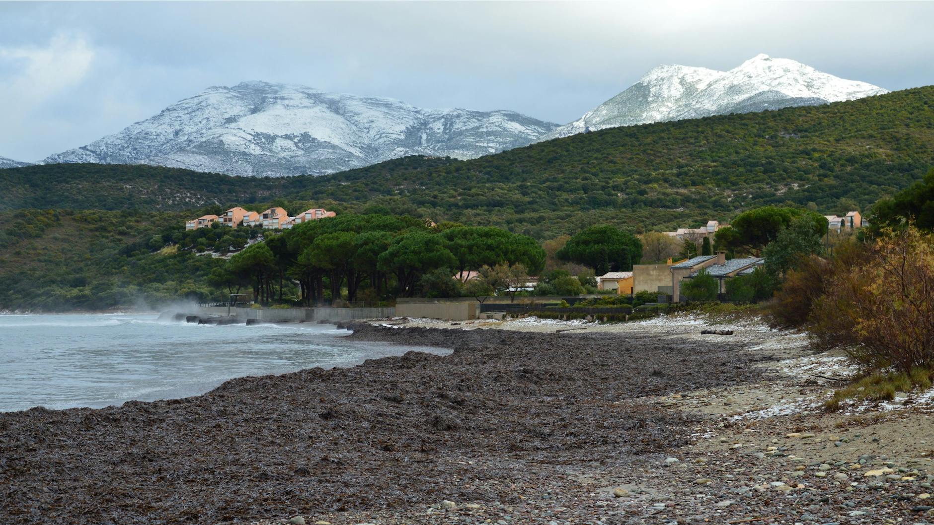 Ośnieżone góry nad spokojną plażą w Saint-Florent na Korsyce