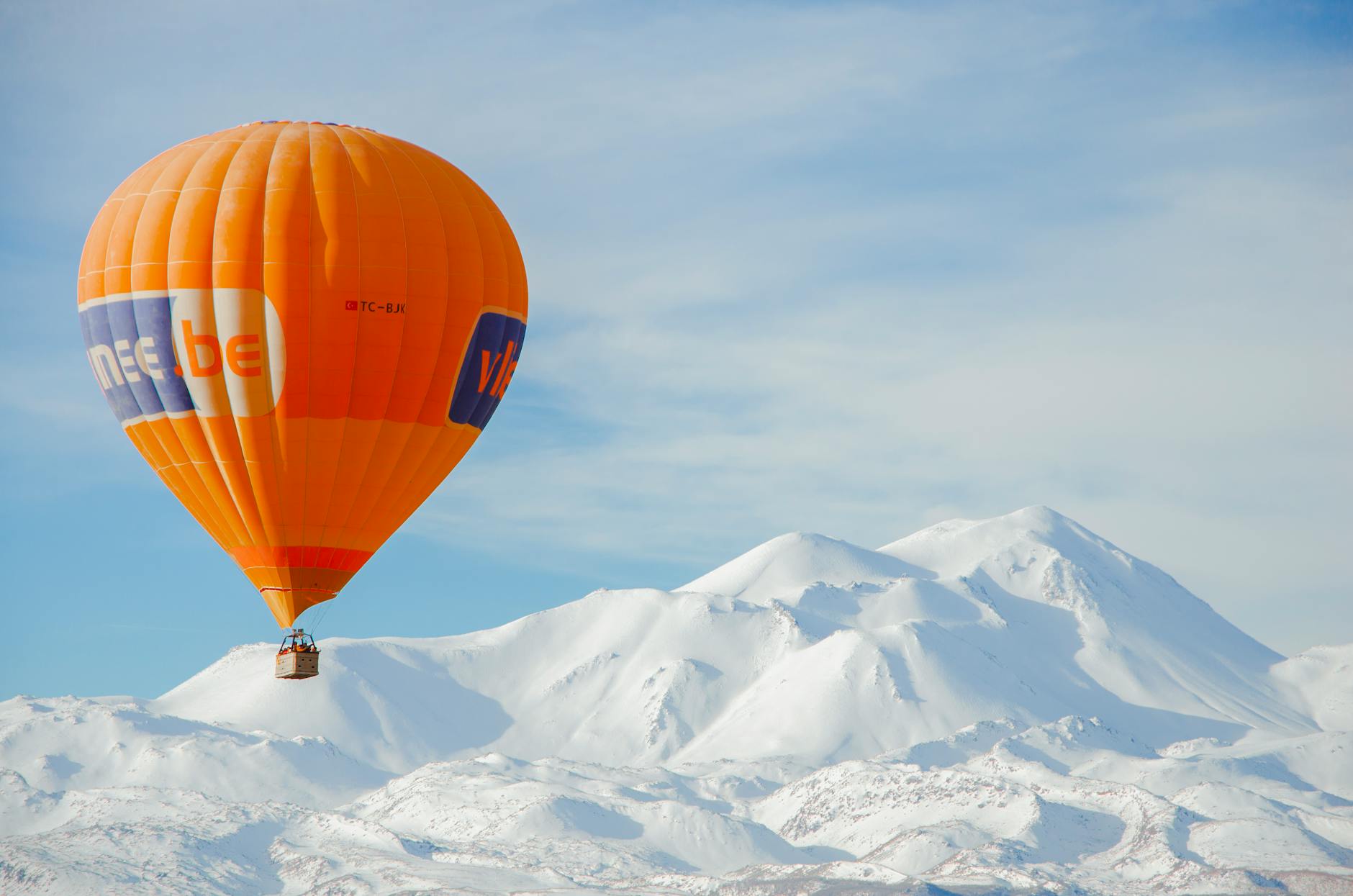 Kapadocja zimą: czy warto, pogoda, ceny i najciekawsze atrakcje bez tłumów Pomarańczowy balon nad ośnieżonym krajobrazem Kapadocji w zimowym słońcu