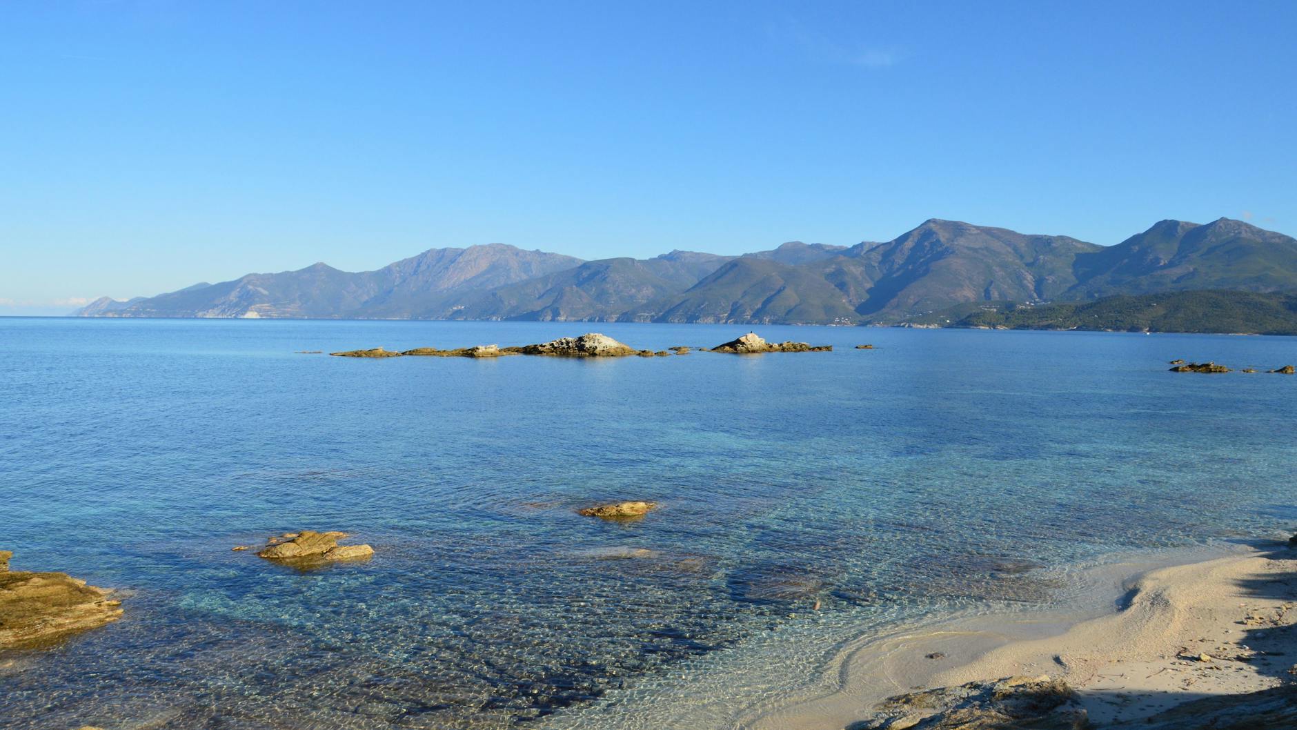 Przejrzyste morze i skaliste góry w Patrimonio na Korsyce poza sezonem