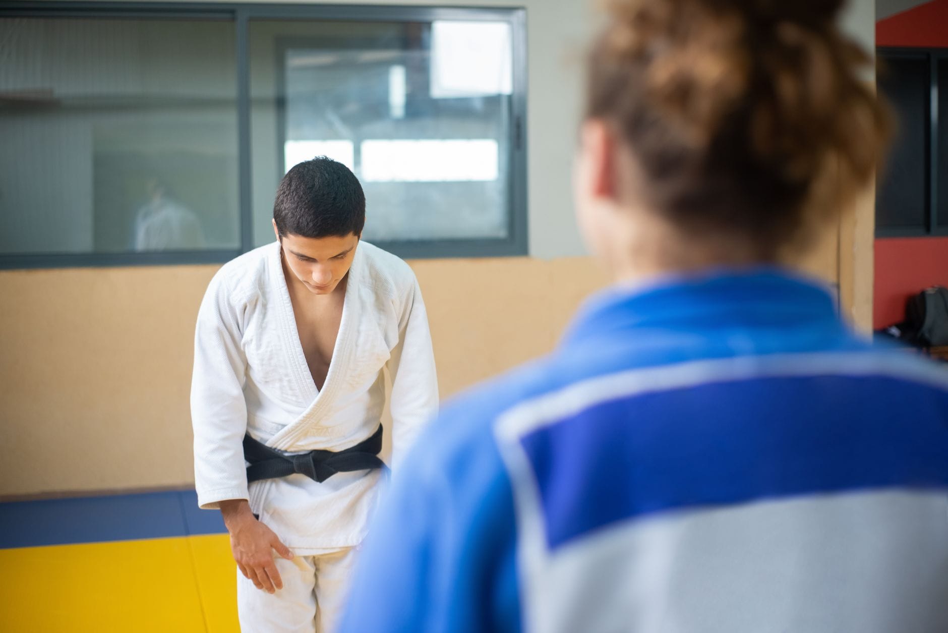 Judoka kłaniający się z szacunkiem podczas treningu judo w dojo