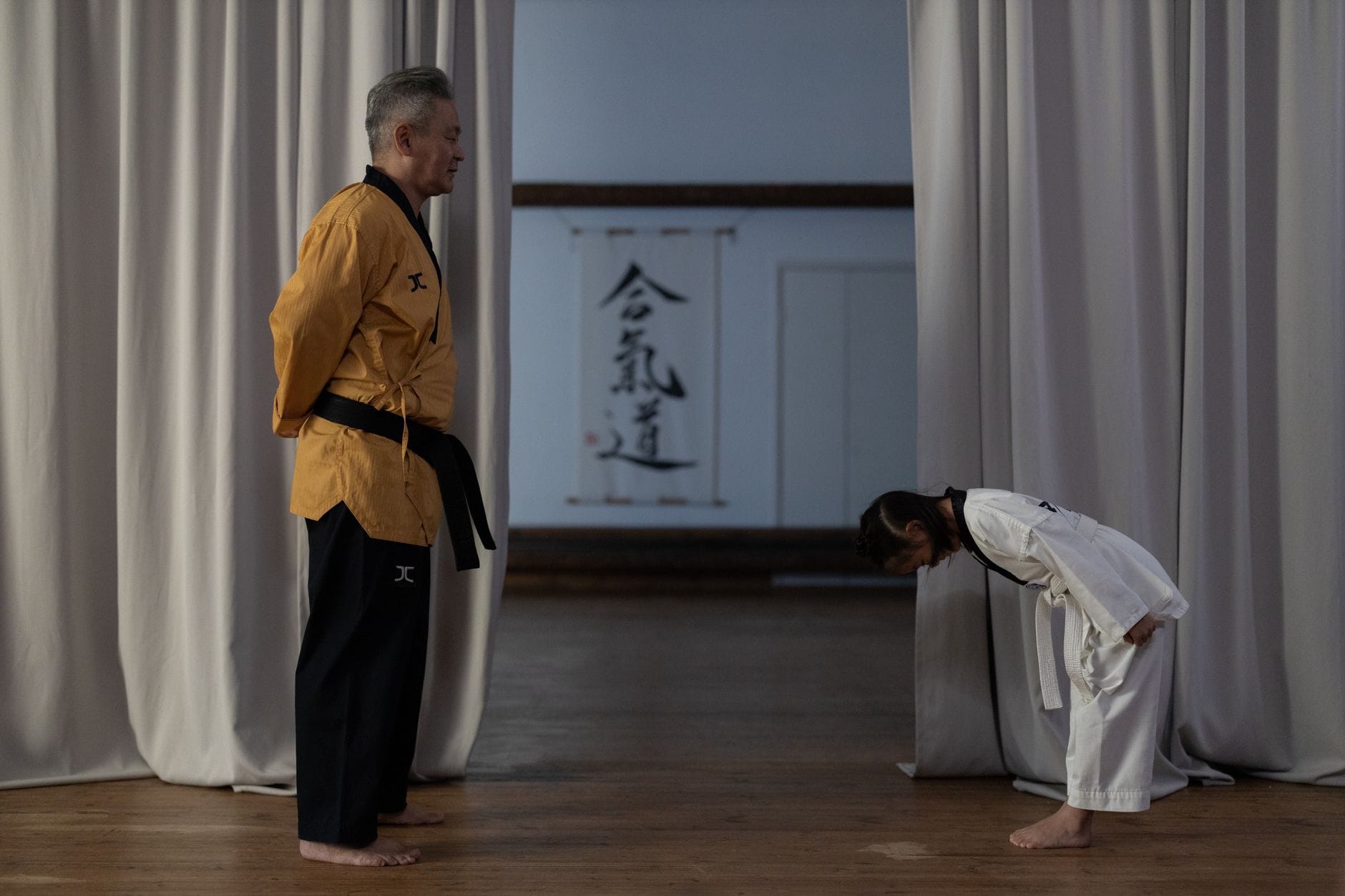 Sensei i dziecko kłaniają się w dojo na zajęciach sztuk walki