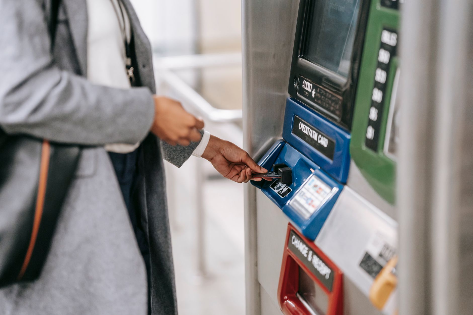 Kobieta kupująca bilet na metro kartą przy automacie biletowym